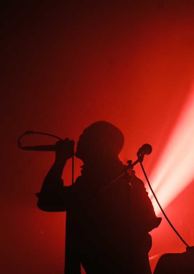 Hands and arms connected by strings, wires and bells
